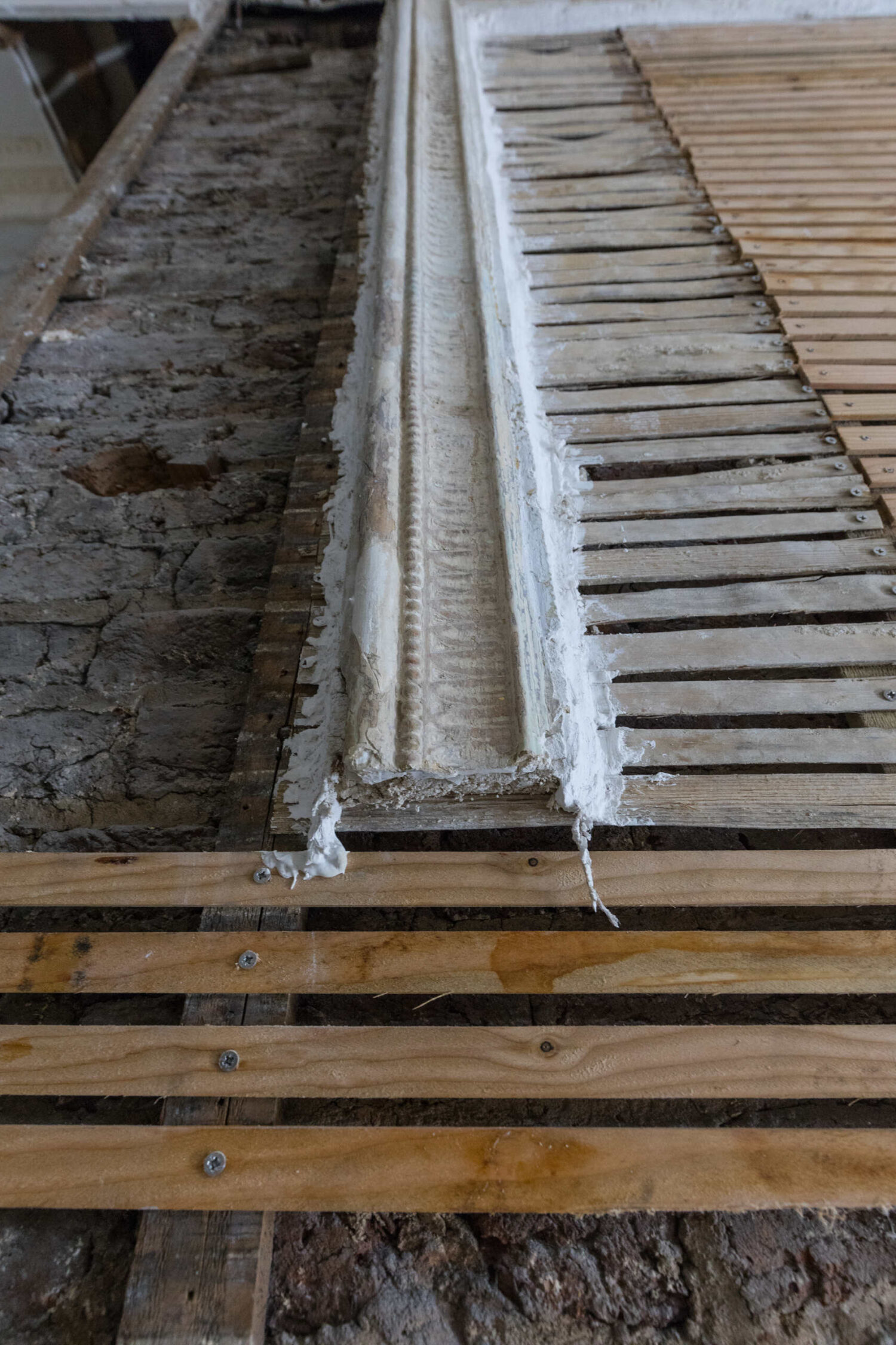 Close-up of a newly installed timber lath wall at the Arding and Hobbs building in London, prepared for traditional lime plaster application. The image highlights material contrasts on site, illustrating the integration of new heritage-appropriate substrates alongside retained historic fabric. Ideal reference for architects focused on compatible materials and breathable construction in conservation projects.